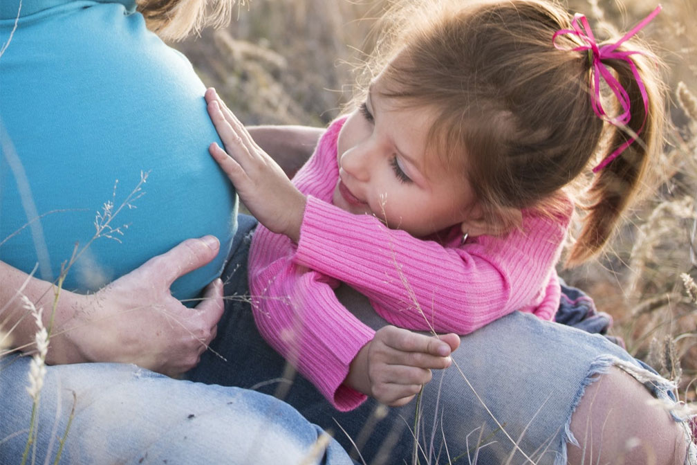 小女孩摸著媽媽的孕肚 小女孩摸著媽媽的孕肚